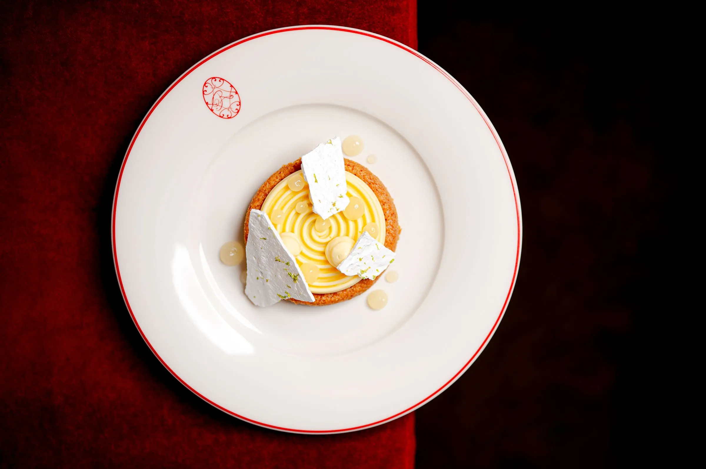 Dessert dressé dans une assiette blanche liserée de rouge, vue du dessus