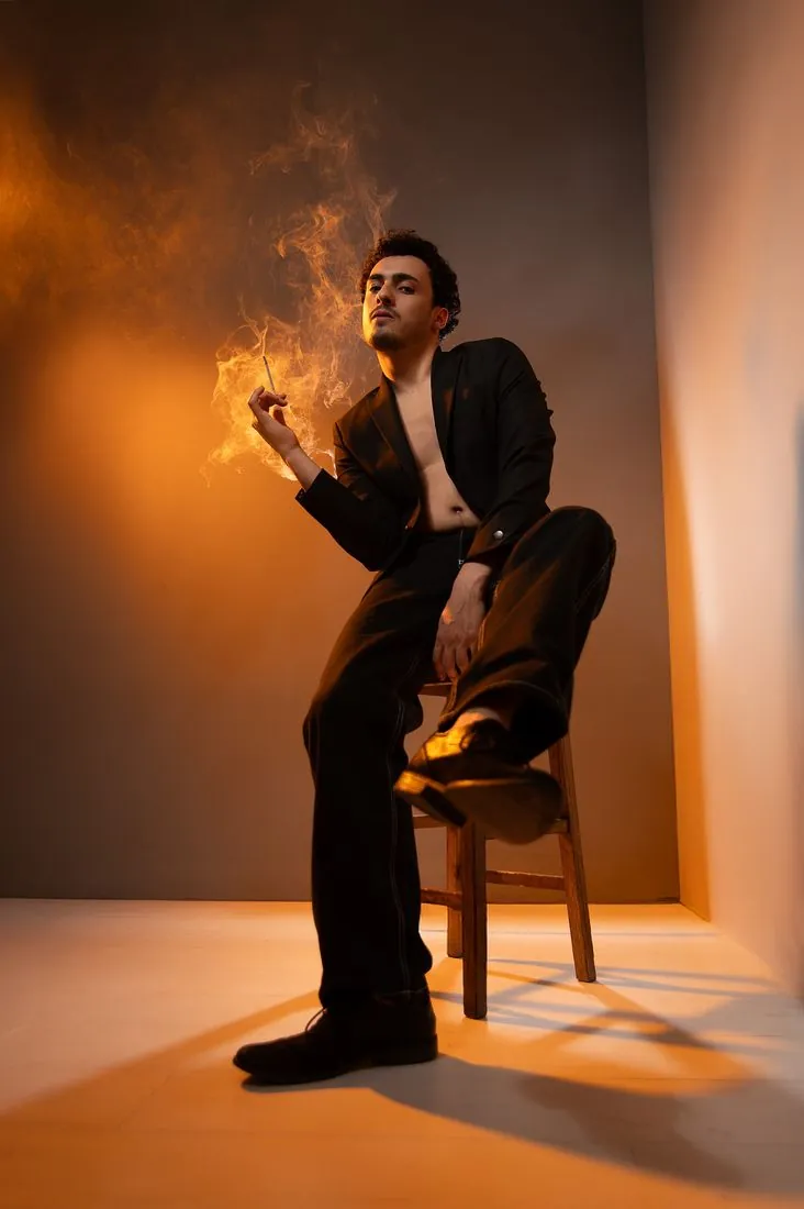 Portrait d’artiste assis, fumée et lumière orangée