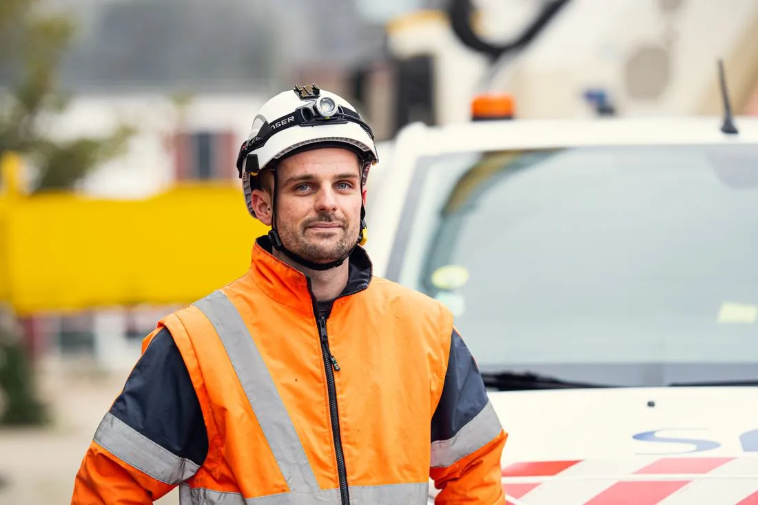 Portrait d’un technicien casqué en veste haute visibilité