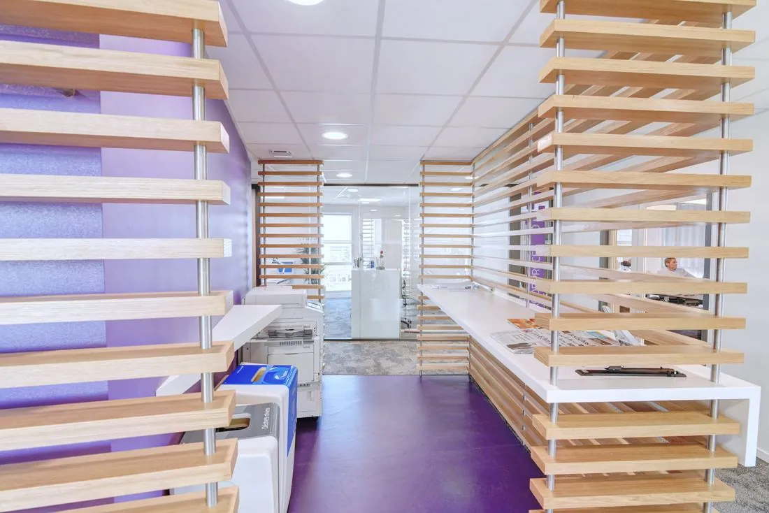 Couloir de bureaux avec claustras en bois et sol violet