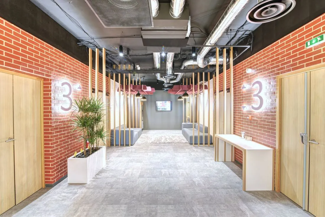 Hall d’étage avec murs en briques et numéros lumineux