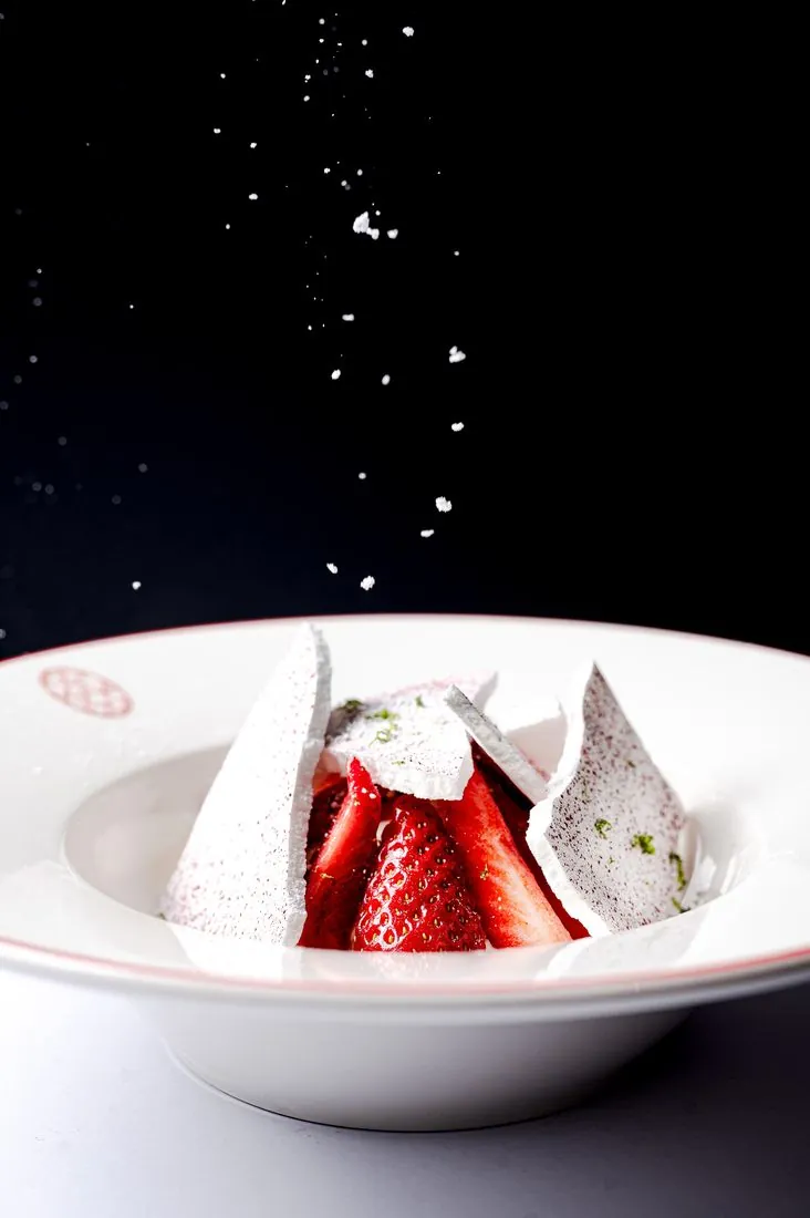 Dessert aux fraises et meringue, sucre glace en suspension