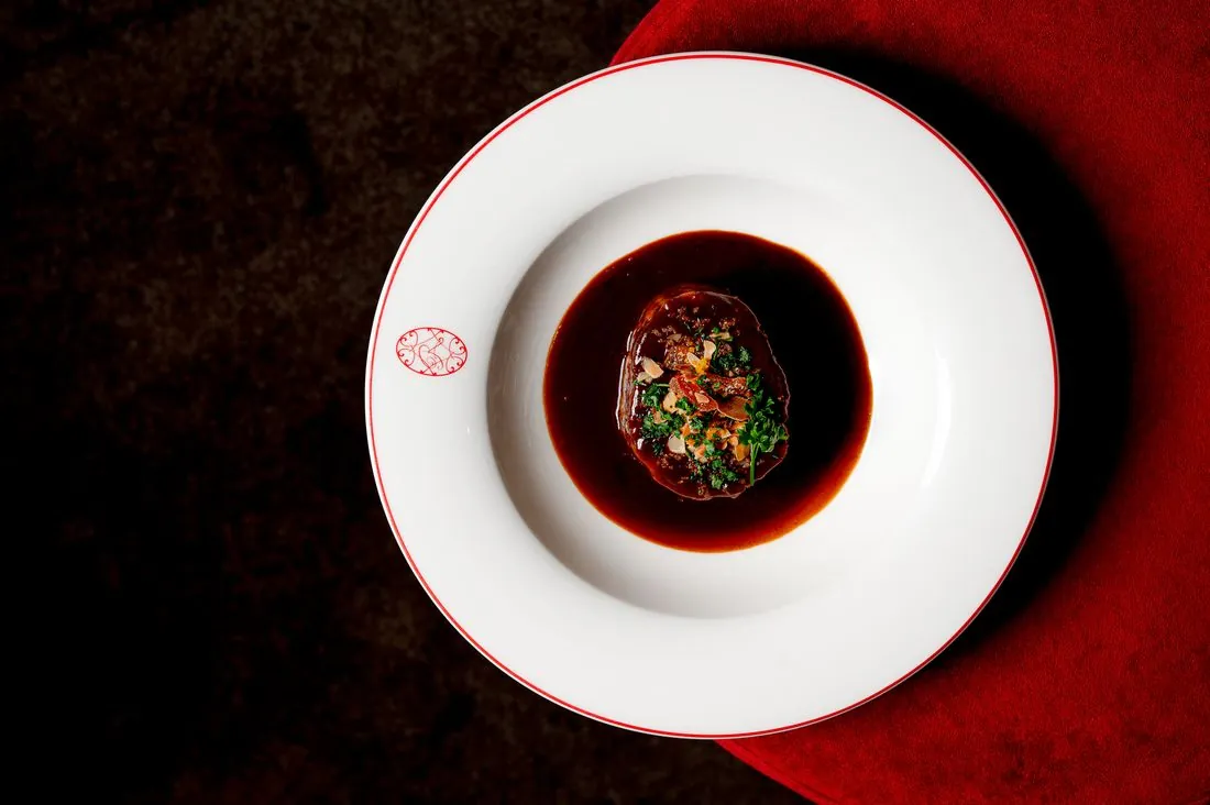 Plat en sauce dans une assiette blanche sur velours rouge