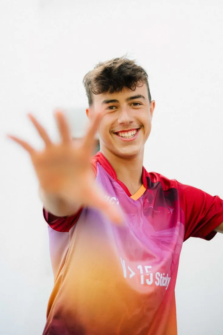 Jeune pongiste souriant, main tendue vers l’objectif