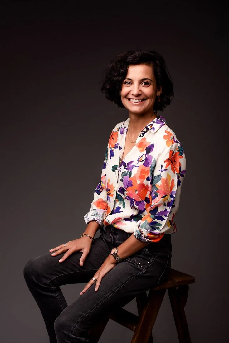 Portrait souriant, chemise fleurie sur fond sombre