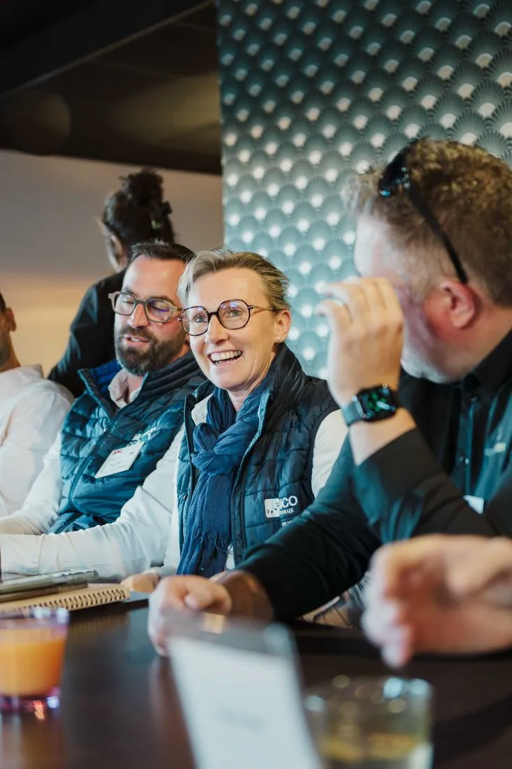 Participants souriants autour d’une table lors d’un petit-déjeuner d’affaires BNI