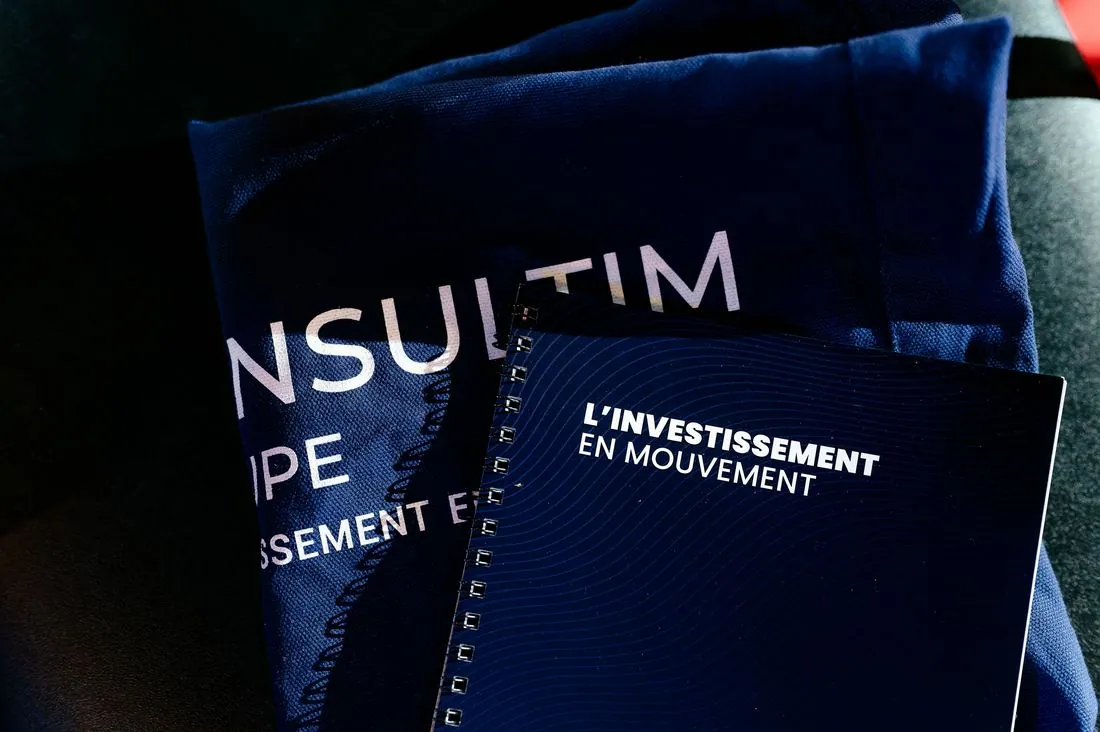Plaquette Consultim « L’investissement en mouvement » posée sur une table