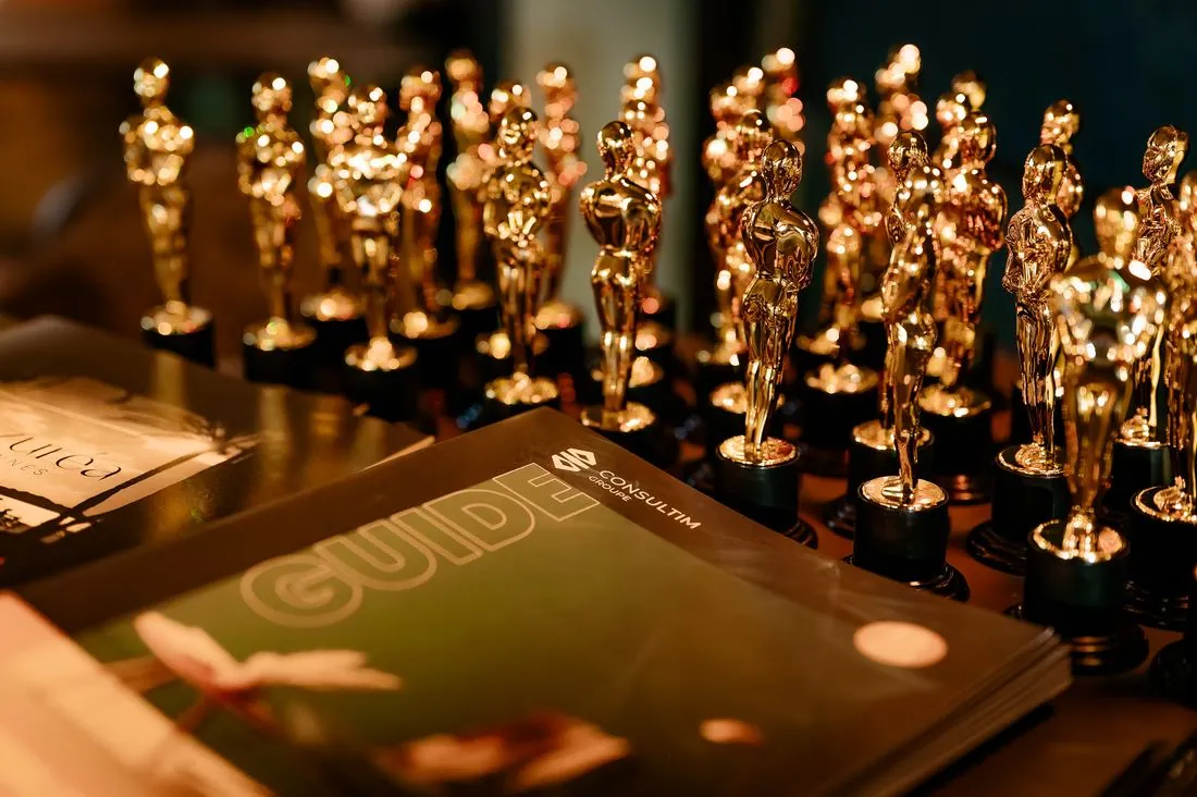 Rangées de trophées dorés et guide officiel lors d’une soirée de prix