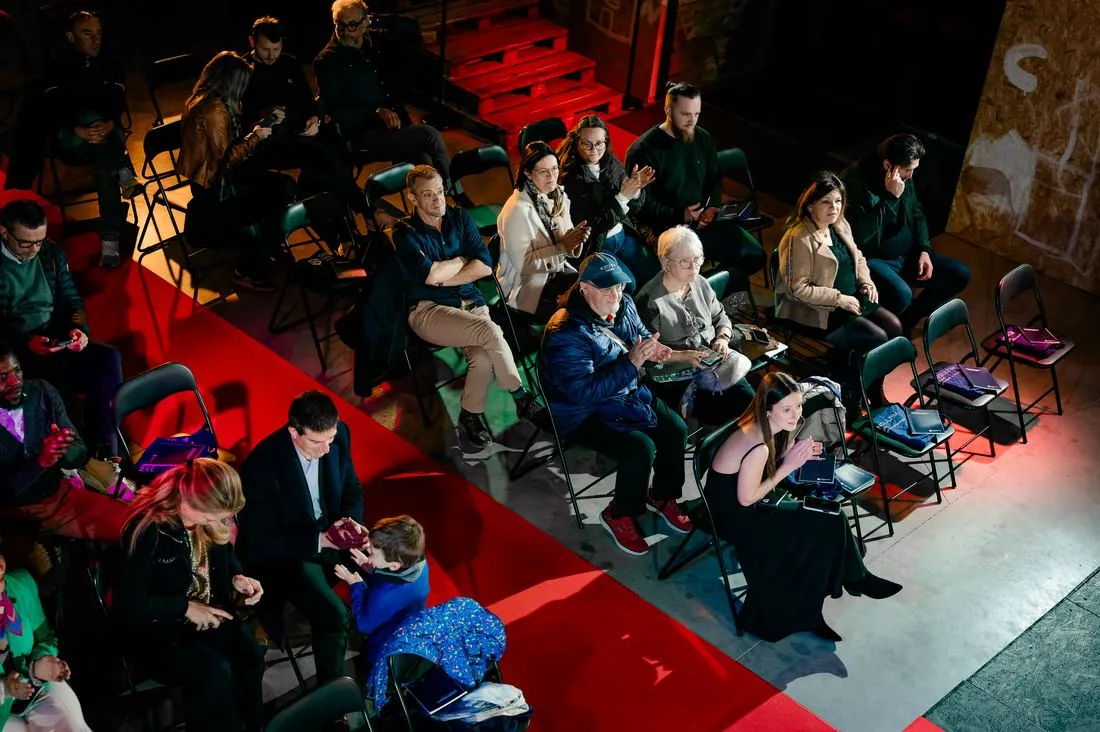 Public installé sur un tapis rouge lors d’une soirée au Hangar