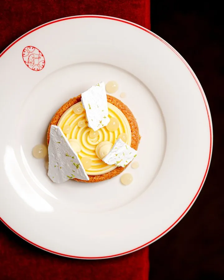 Dessert dressé dans une assiette blanche liserée de rouge, vue du dessus