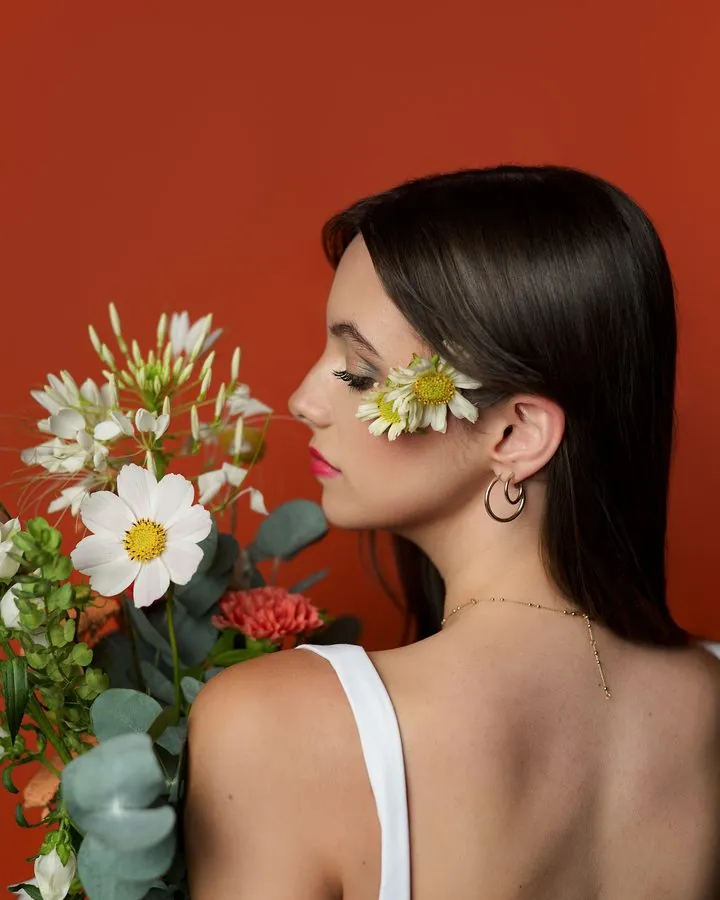 Mannequin de dos avec un bouquet de fleurs sur fond orange